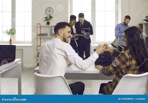 Two Business People Or Colleagues Making A Deal And Fist Bumping Sitting At Office Table Stock