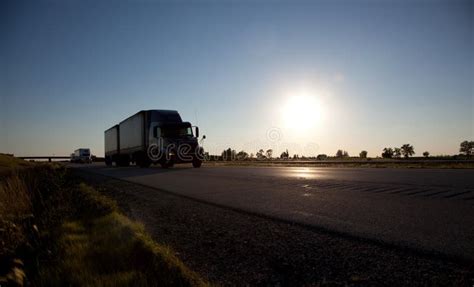 Semi Trucks With Trailers Carrying Cargo On The Highway Stock Photo