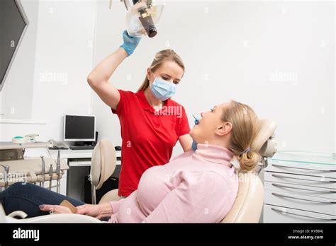 Woman With Open Mouth Having Her Teeth Examined By Female Dentist Teeth Checkup At Dentists