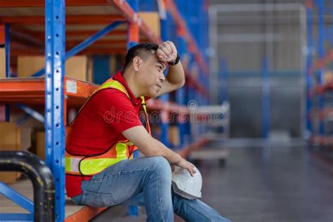 tired stress asian male worker labor hard working fatigue sitting resting in warehouse cargo