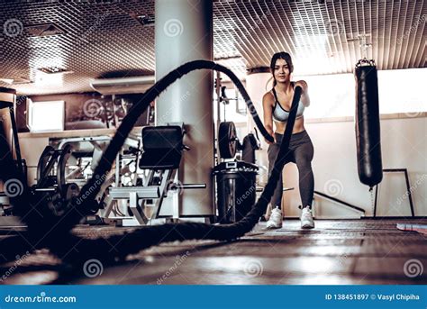 Powerful Attractive Muscular Woman Trainer Do Battle Workout With Ropes At The Gym Stock Image