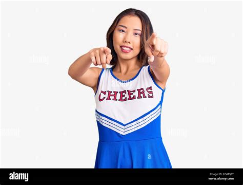 Young Beautiful Chinese Girl Wearing Cheerleader Uniform Pointing To