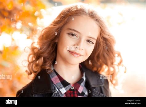 Smiling Blonde Teen Girl With Curly Hair 12 14 Year Old Posing Outdoors Over Autumn Nature