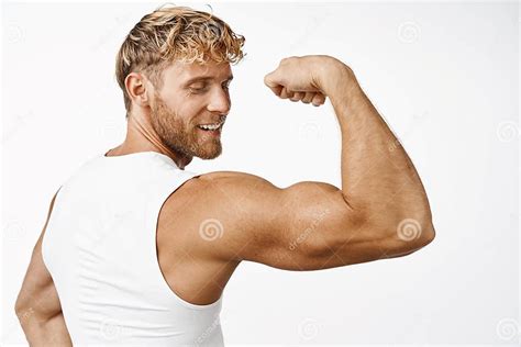 Portrit Of Handsome Male Athlete Rear View Flexing Biceps And Smiling