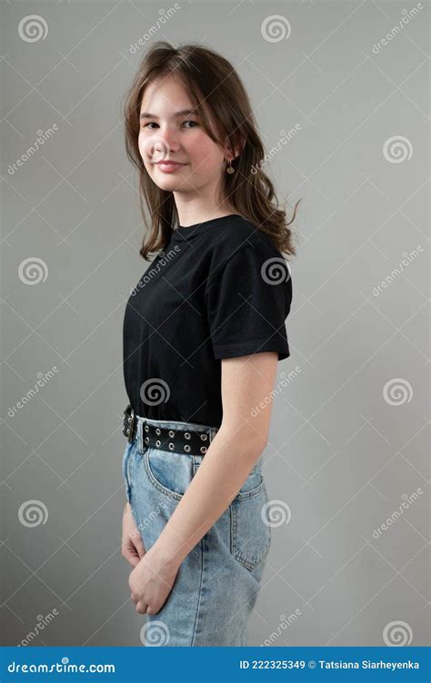 Portrait Of A Shy Brunette Teen Girl In Black T Shirt On Gray Background Stock Image Image Of
