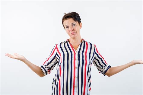 free photo mature woman showing helpless gesture in striped shirt and looking puzzled front