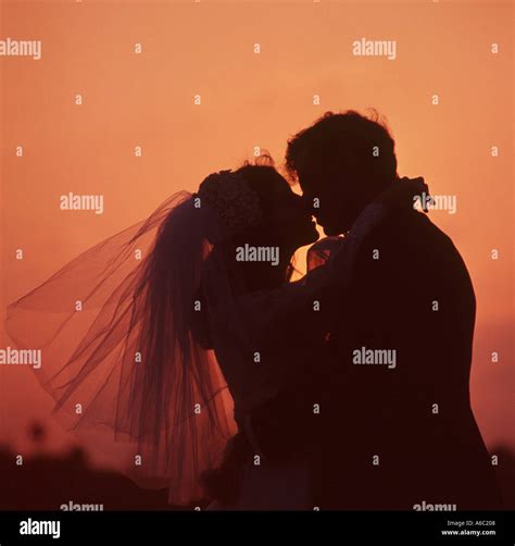 Bride And Groom Kissing At Outdoor Wedding At Sunset Stock Photo Alamy