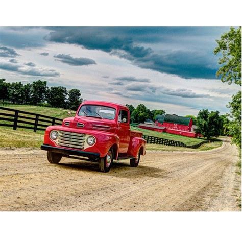 It's the quintessential manifestation of american freedom. Vintage cherry red truck driving down a country dirt road. Red barn. Wood fence. Green field ...