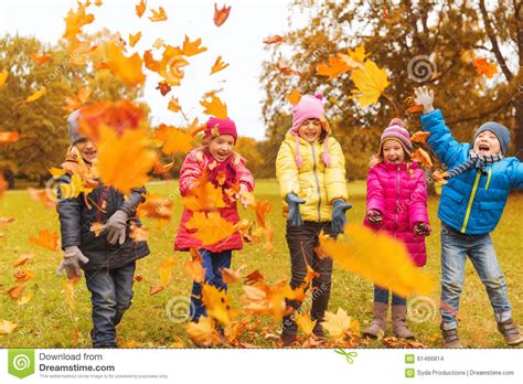 Happy Children Playing With Autumn Leaves In Park Stock Photo Image