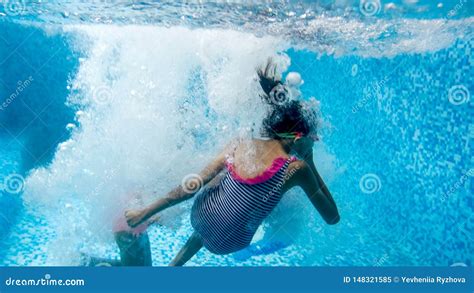 Underwater Image Of Two Teenage Girl Jumping And Diving In Swimming