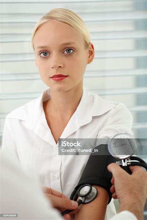 Doctor Measuring Young Womans Blood Pressure Stock Photo Download