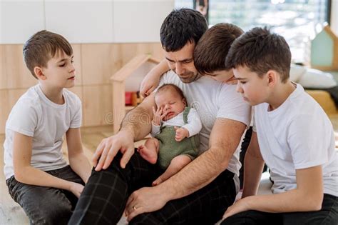 Portrait Of Father And His Four Sons Holding His Newborn Baby Stock