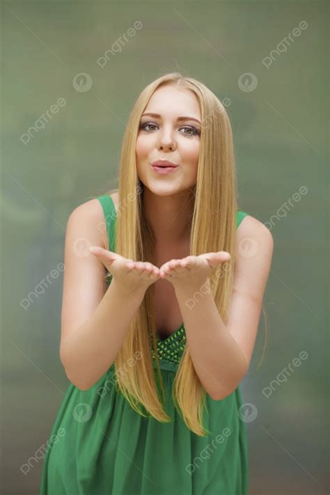 Young Blonde Woman Blowing While Sending An Air Kiss Photo Background