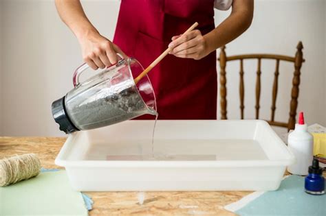 Free Photo Midsection View Of A Womans Hand Mixing Paper Pulp In Water