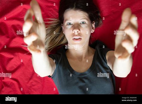 The Girl Lies In A Bed On A Red Sheet And Stretches Her Arms To The Top Sleep And Rest At Home