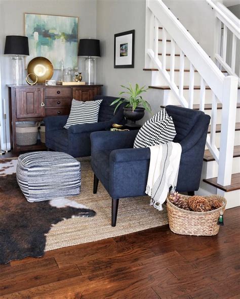 Living Room With Abstract Art Navy Chairs Jute Rug And Faux Cowhide
