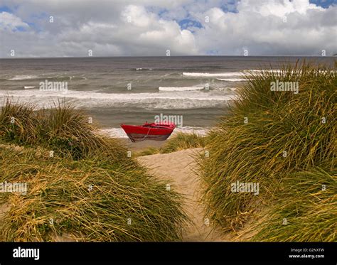 Oregon Coastal Scene With Sand Dunes Grass Waves And A Red Boat Stock