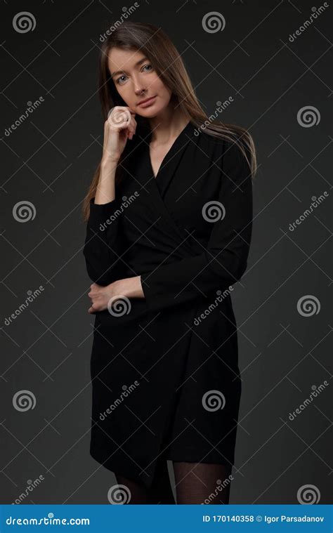 Beautiful Girl In A Black Dress On A Gray Background Stock Photo