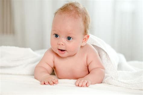Newborn Baby With Beautiful Blue Eyes Lying On Belly Stock Photo