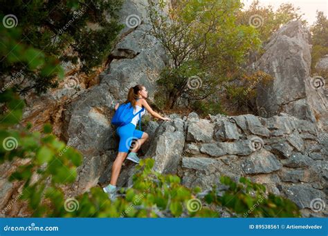 Young Woman Hiker With Backpack Walking A Trail In Rocky Mountains