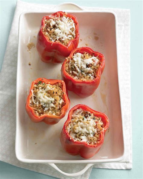 Four Stuffed Red Peppers On A Plate With Cheese And Seasoning In The