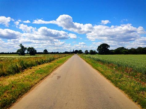 Long Straight Country Road With Fields And Blue Sky In Lincolnshire