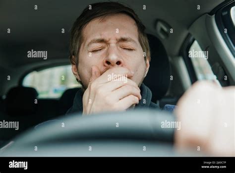 Close Up Portrait Sleepy Young Man Driver Yawning On The Front Seat Of