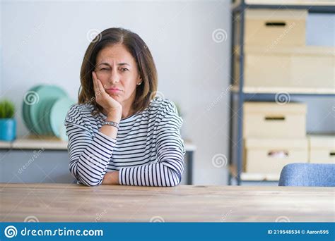 Middle Age Senior Woman Sitting At The Table At Home Thinking Looking