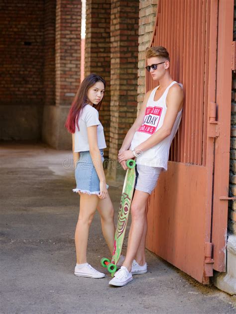 Een Leuk Paar Van Een Meisje En Haar Vriend Met Een Skateboard Op Een Straatachtergrond