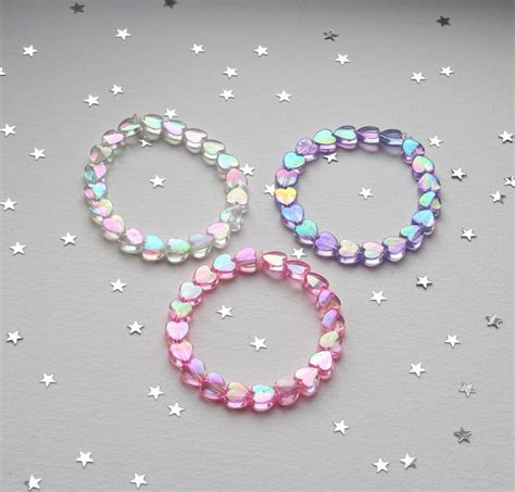 Three Bracelets With Pastel Colors And White Stars On A Gray Background One Is Pink The Other