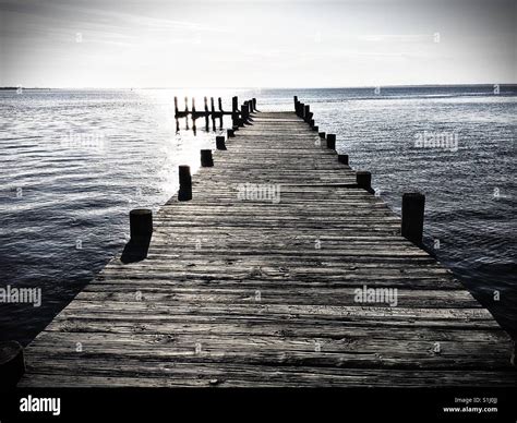 A Weathered Dock Extends Out Into The Water Stock Photo Alamy