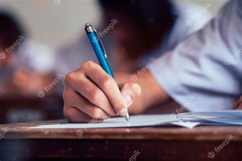 Premium Photo Close Up To Student Holding Pencil And Writing Final Exam
