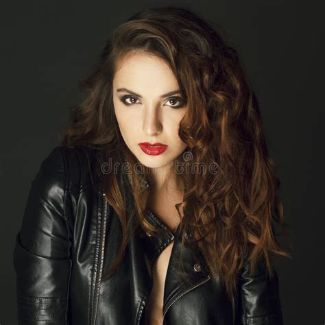 Beautiful Young Woman Posing In Black Leather Jacket Over Grey B Stock