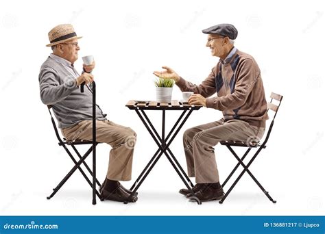 two senior men sitting at a coffee table and talking stock image image of mature pensioner