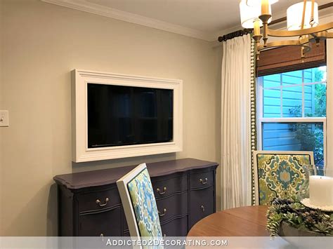 A simple hinged panel with a piece of art on the front can quickly hide a tv. Custom DIY Frame For Wall-Mounted TV - Finished!