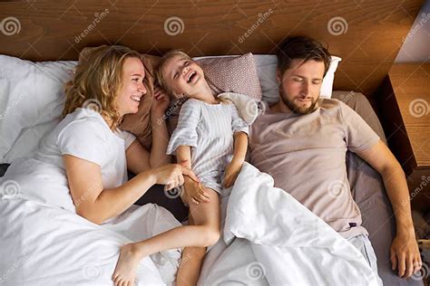 Moeder En Dochter Hebben Plezier In Bed Terwijl Vader Slaapt Stock Foto