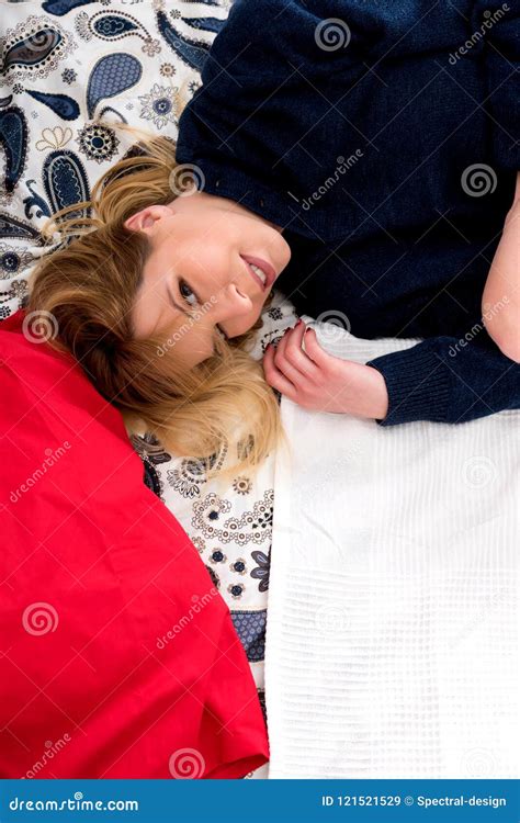 A Smiling Young Woman Lying On A Bed In A Sweater Stock Image Image