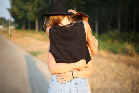 Two Female Friends Hugging From Behind By Stocksy Contributor Mak Stocksy