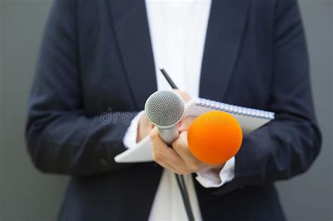 Tv Journalist Or News Reporter Holding Microphone And Taking Notes At