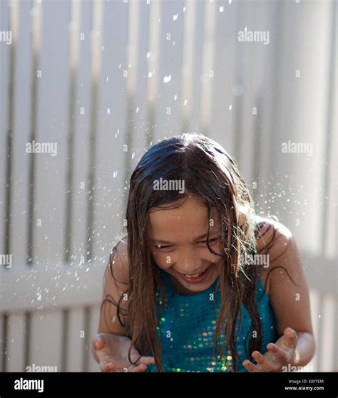 Girl Being Sprayed With Water In The Garden Stock Photo Alamy