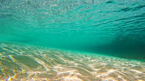 Underwater Shallow Sandy Ocean Floor With Sunlight Through Water