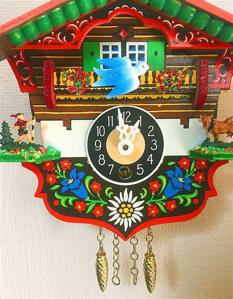 A Colorful Cuckoo Clock Hanging From The Side Of A Wall