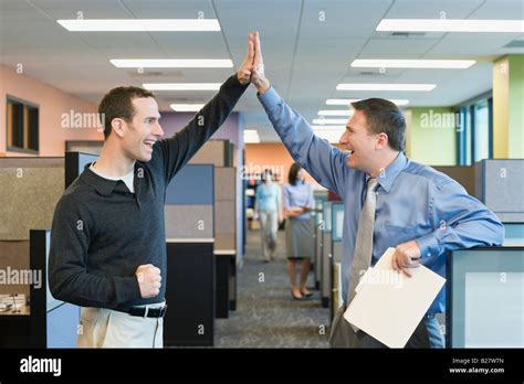 Businessmen High Fiving In Office Stock Photo Alamy