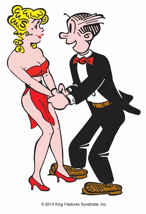 A Man In A Tuxedo Is Dancing With A Woman Wearing A Red Dress