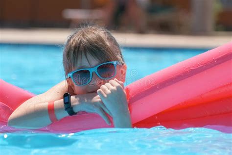 Young Joyful Child Girl Having Fun Swimming On Inflatable Air Mattress