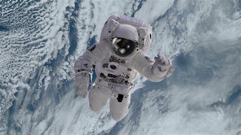 Astronaut In Outer Space Slowly Drifting Or Falling Towards Earth