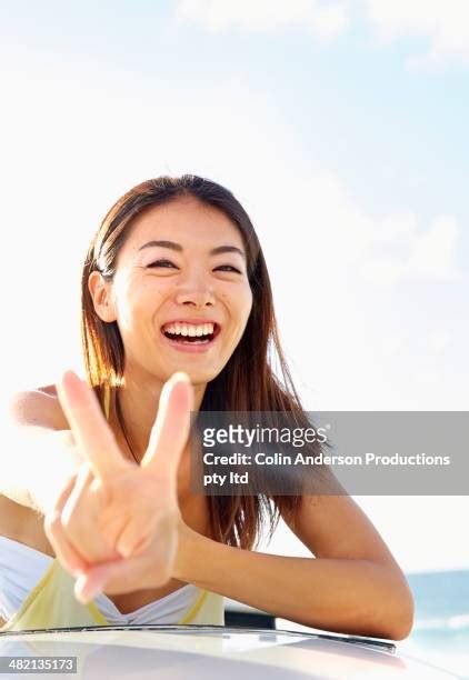 close up of asian woman making peace sign photos and premium high res pictures getty images