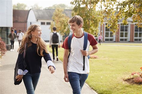 Teenage Students Walking Around College Campus Together Stock Photo By