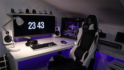 A Desk With A Computer And Speakers On It In A Room That Is Lit Up