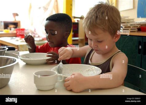 Dpa Two Children Sit Next To Each Other At A Table And Eat Their